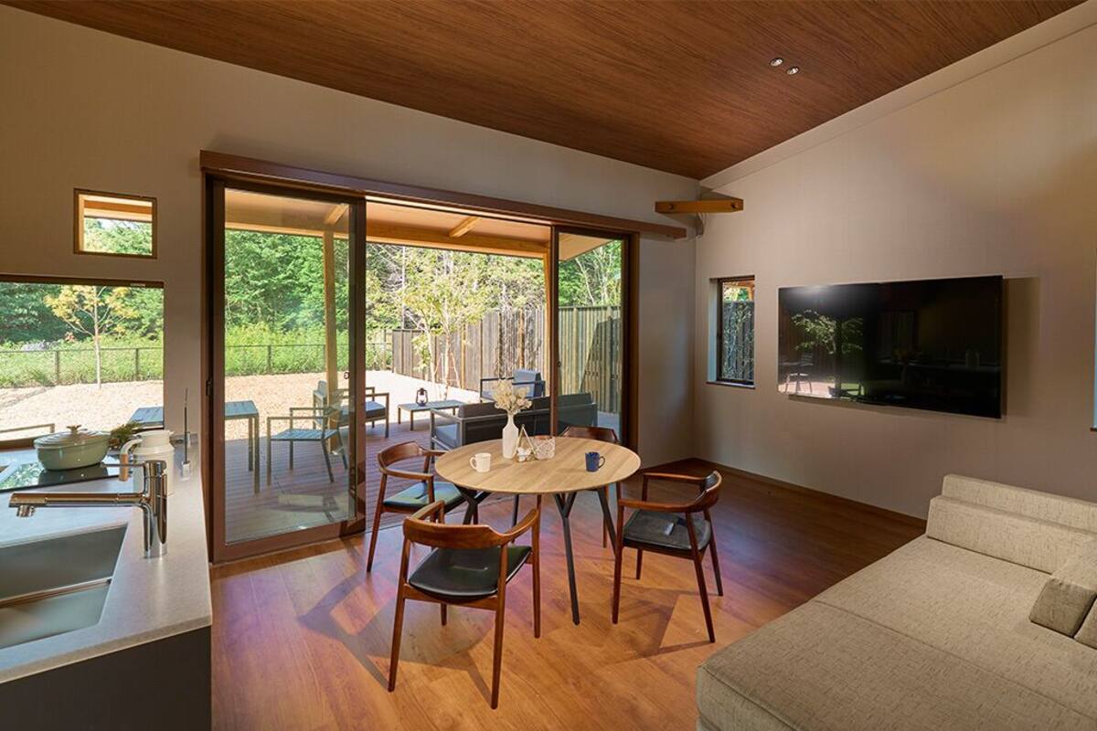 Un salon moderne avec un plancher en bois, une table à manger ronde et un canapé.