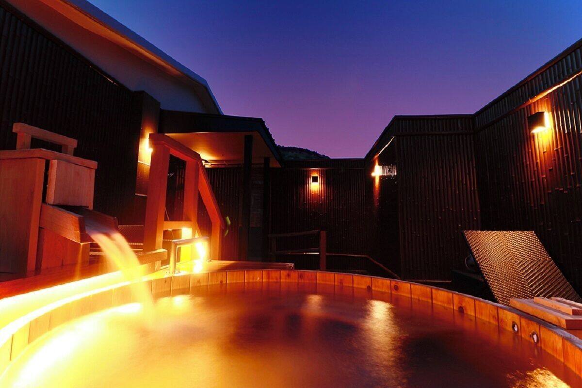 Zona de piscina exterior climatizada con paredes y cubierta de madera.