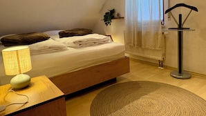 A bedroom with a bed, bedside lamp, bedside table, and a radiator.