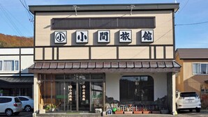 A building with a sign that reads '小間農館' and a storefront with large windows.