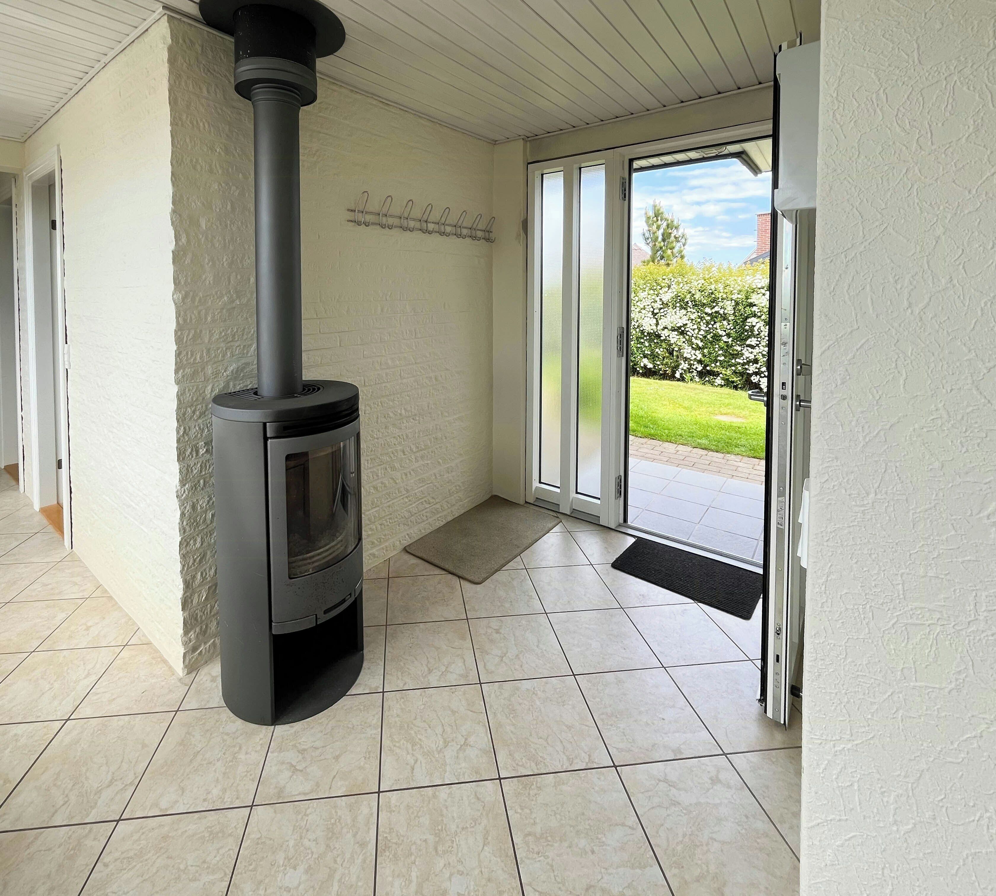 A room with a fireplace, a sliding glass door to the outside, and a tiled floor.