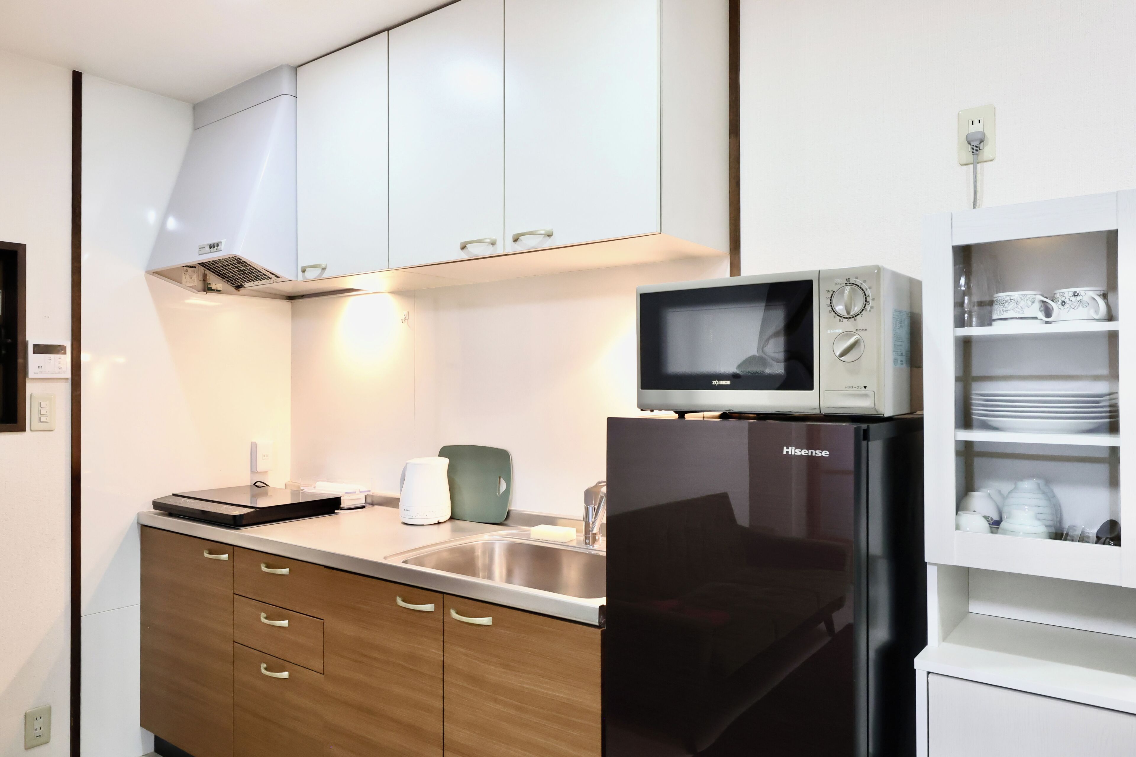 A modern kitchen with a stainless steel refrigerator, a microwave, and a sink.