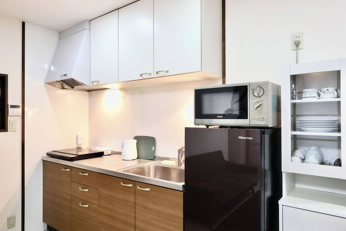 A modern kitchen with a stainless steel refrigerator, a microwave, and a sink.