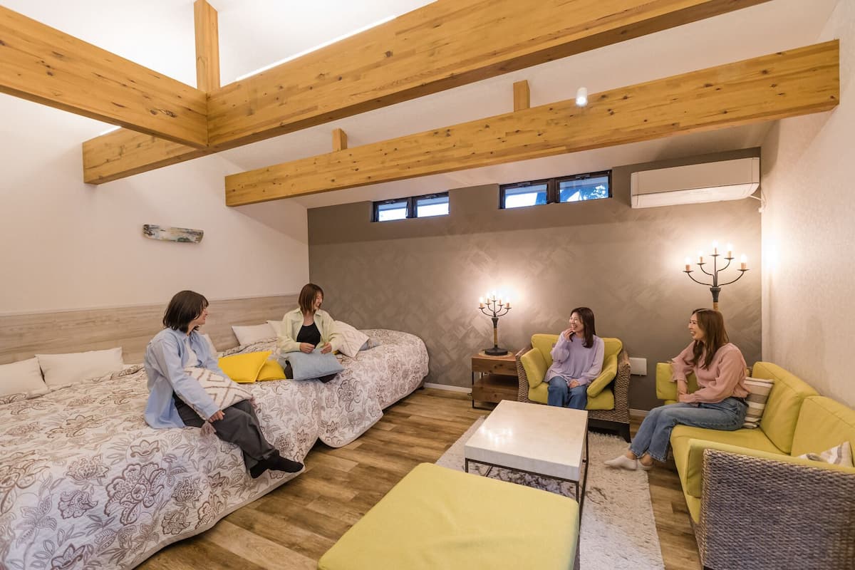 Ein Zimmer mit einem Bett, zwei Sofas, einem kleinen Tisch und einem Kerzenleuchter.
