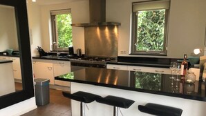 Una cucina moderna con isola centrale, elettrodomestici in acciaio inossidabile e un'ampia finestra.