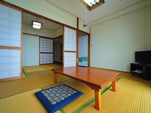 Ein traditioneller japanischer Raum mit Tatami-Böden, einem niedrigen Holztisch und Schiebetüren.