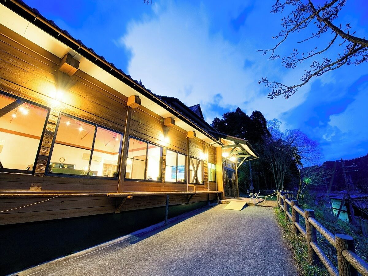 A wooden building with large windows and a covered walkway.