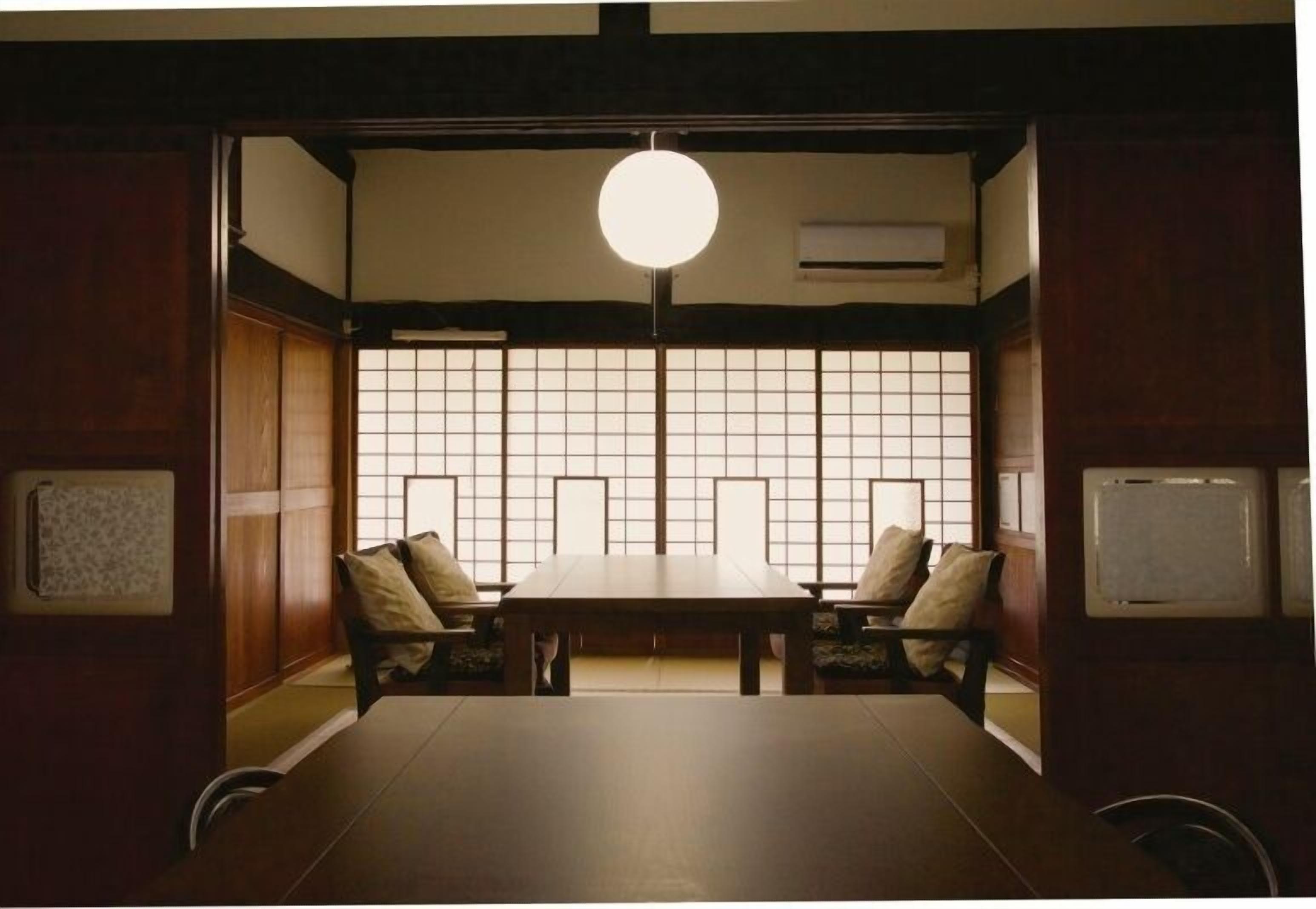 A traditional Japanese room with tatami flooring, a low table, and sliding doors.