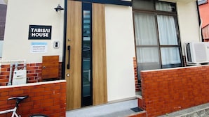 Ein zweistöckiges Gebäude mit einem Schild, auf dem 'Tabisai House' steht.