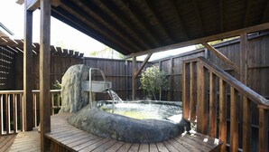 Une terrasse en bois avec un jacuzzi, un escalier en bois et une clôture en bois.