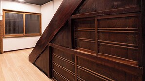 A room with a wooden floor, a large window, and a dark wooden garage door. - Hakone Yumoto Onsen Ryokan Yamatokan (Hakone)