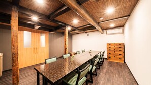 A conference room with a long table, chairs, wooden beams, and a patterned wall. - Hakone Yumoto Onsen Ryokan Yamatokan (Hakone)