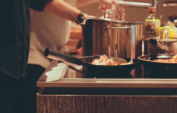 A kitchen counter with a pot, a pan, and a bottle of oil.
