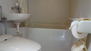 A bathroom with a toilet, sink, and bathtub.