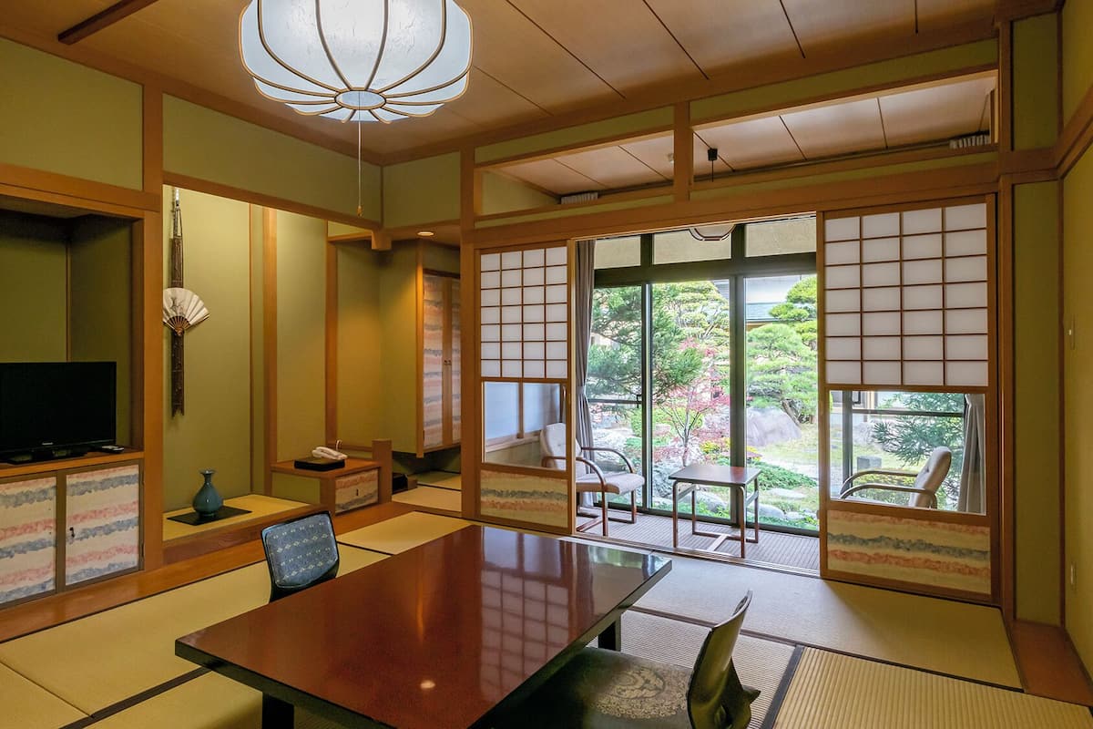 A traditional Japanese-style room with tatami flooring, a low table, and sliding doors.