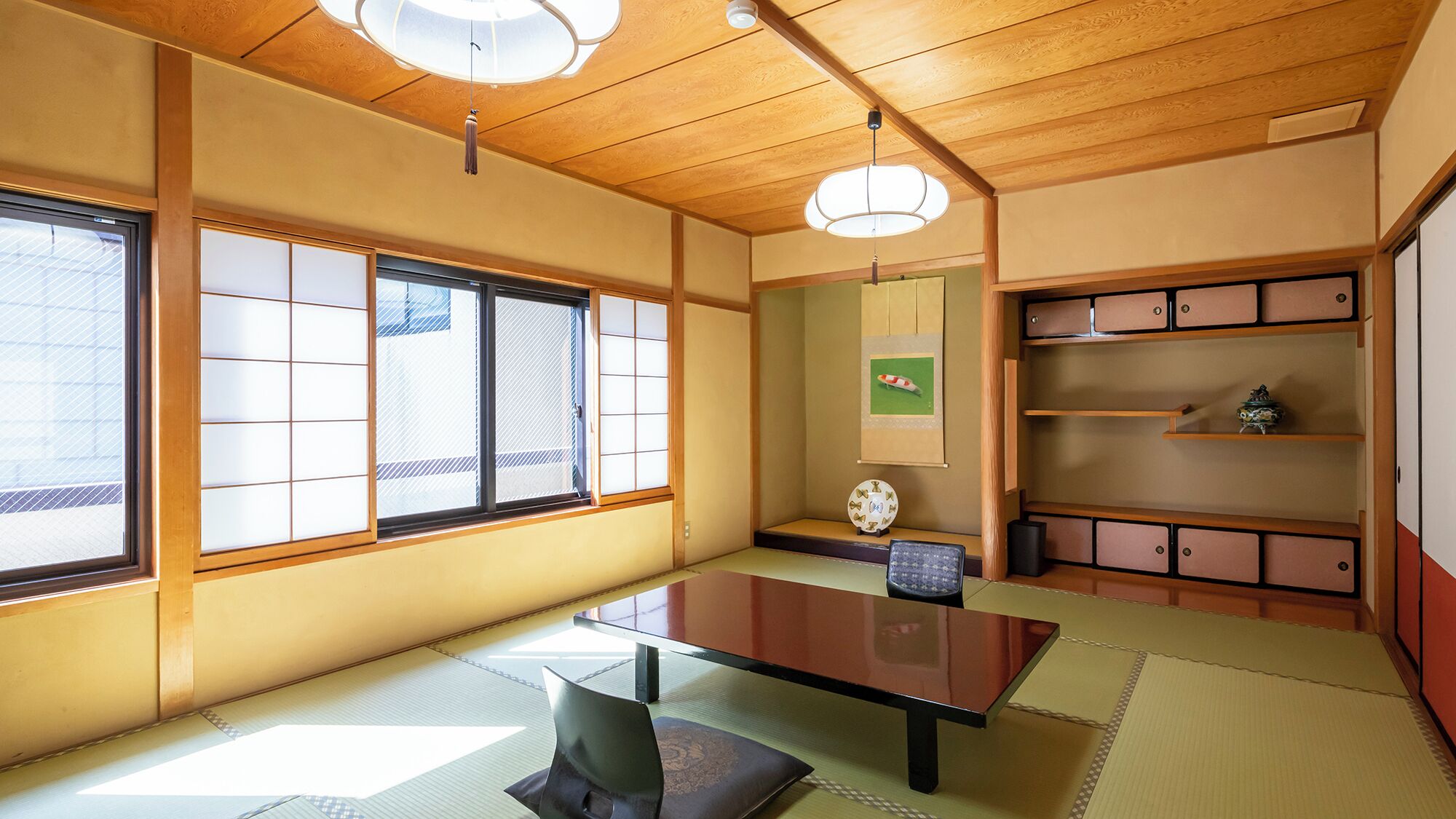 Um quarto japonês tradicional com tatames, uma mesa baixa, portas deslizantes e uma estante com objetos decorativos.
