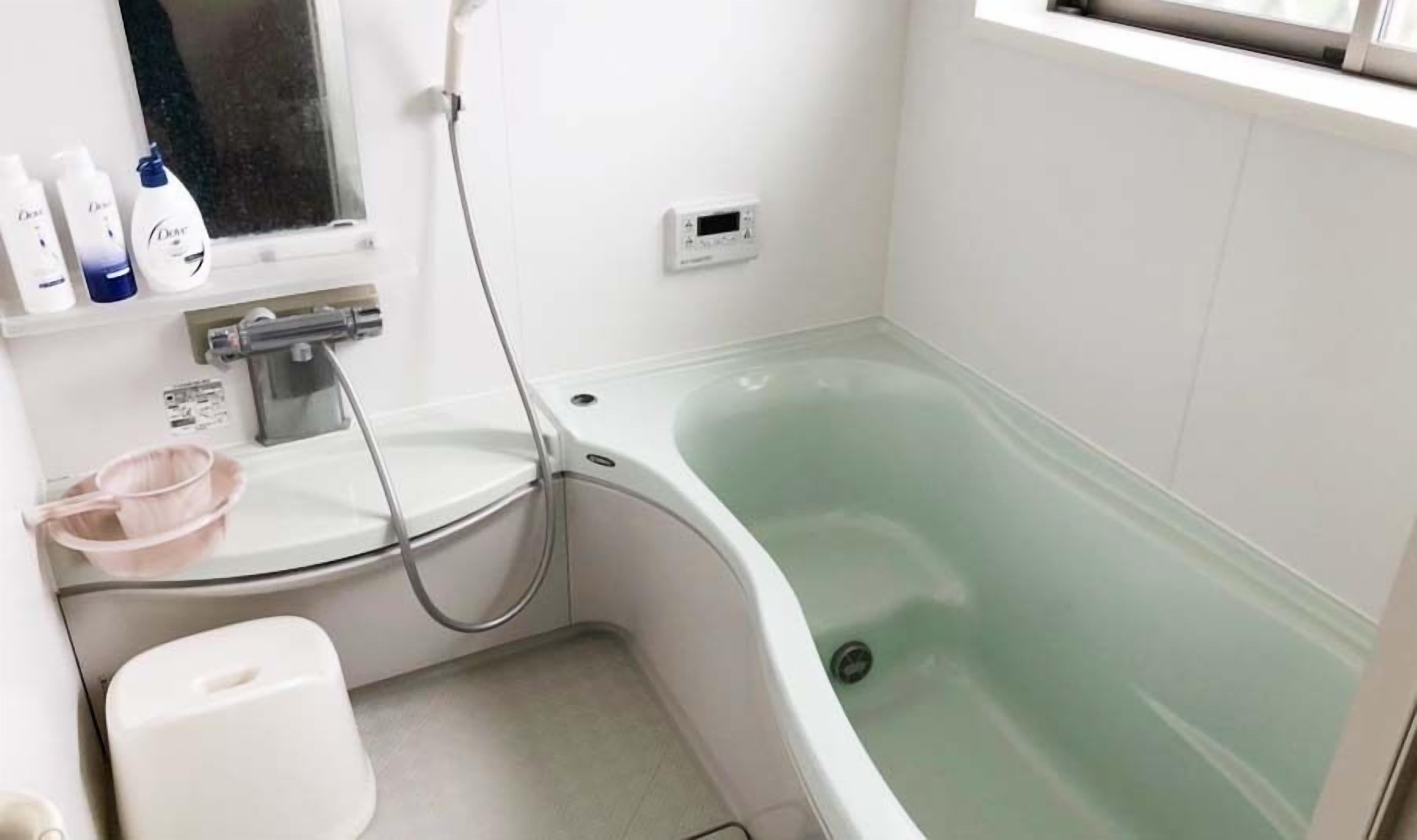 A bathroom with a bathtub, a toilet, a sink, and a window.