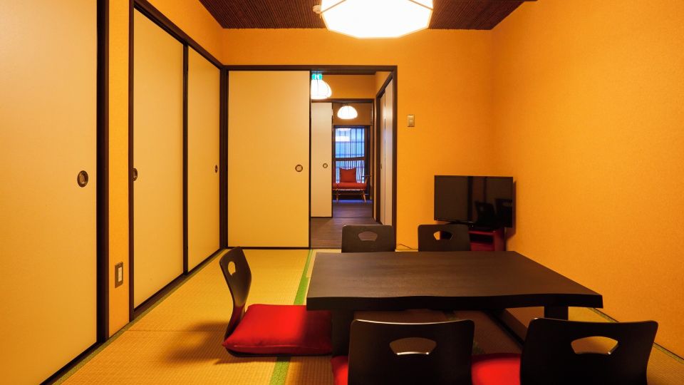 A room with tatami flooring, a low table, and traditional Japanese-style chairs.
