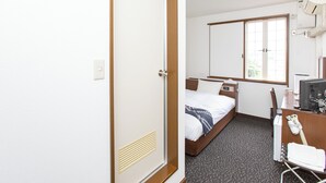 A hotel room with a bed, a desk with a computer, a mirror, and a window. - Business Hotel Tsukidate (Kurihara)