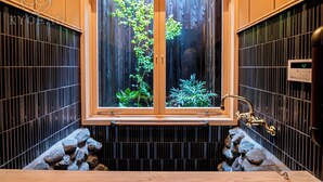 A bathroom with a wooden vanity, a window with a view of greenery, and a wall-mounted faucet. - Kyoran Satsukitei (Kyoto)
