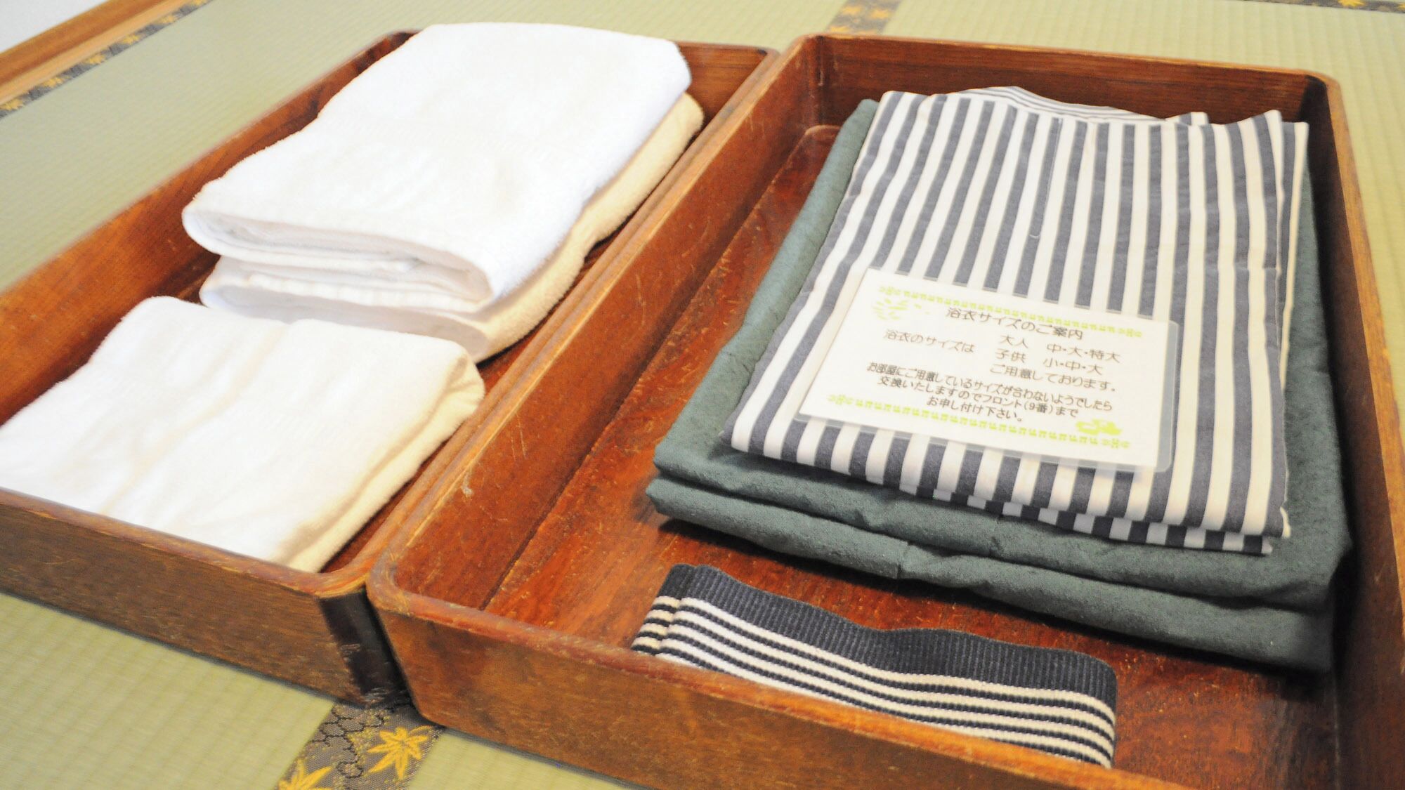 A wooden tray with folded towels and a tag.