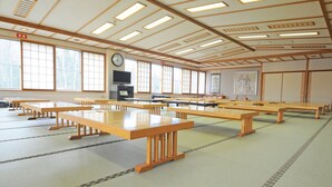 A traditional Japanese room with tatami flooring, wooden tables, a television, and a clock on the wall. - Efre (Kushiro)