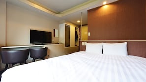 A hotel room with a bed, a TV, a desk, and two chairs. - Suiyotei (Atami)