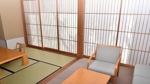 A traditional Japanese room with tatami flooring, a low table, and a cushioned chair. - Suzumushiso (Matsukawa)