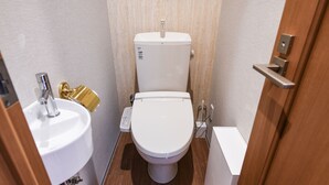 A compact bathroom with a white toilet, a sink, and a shower. - Bnb+ Kanda Terrace Ogawamachi (Tokyo)