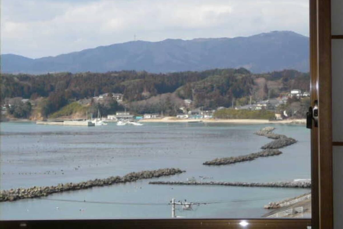 A coastal view with mountains, a beach, and boats.
