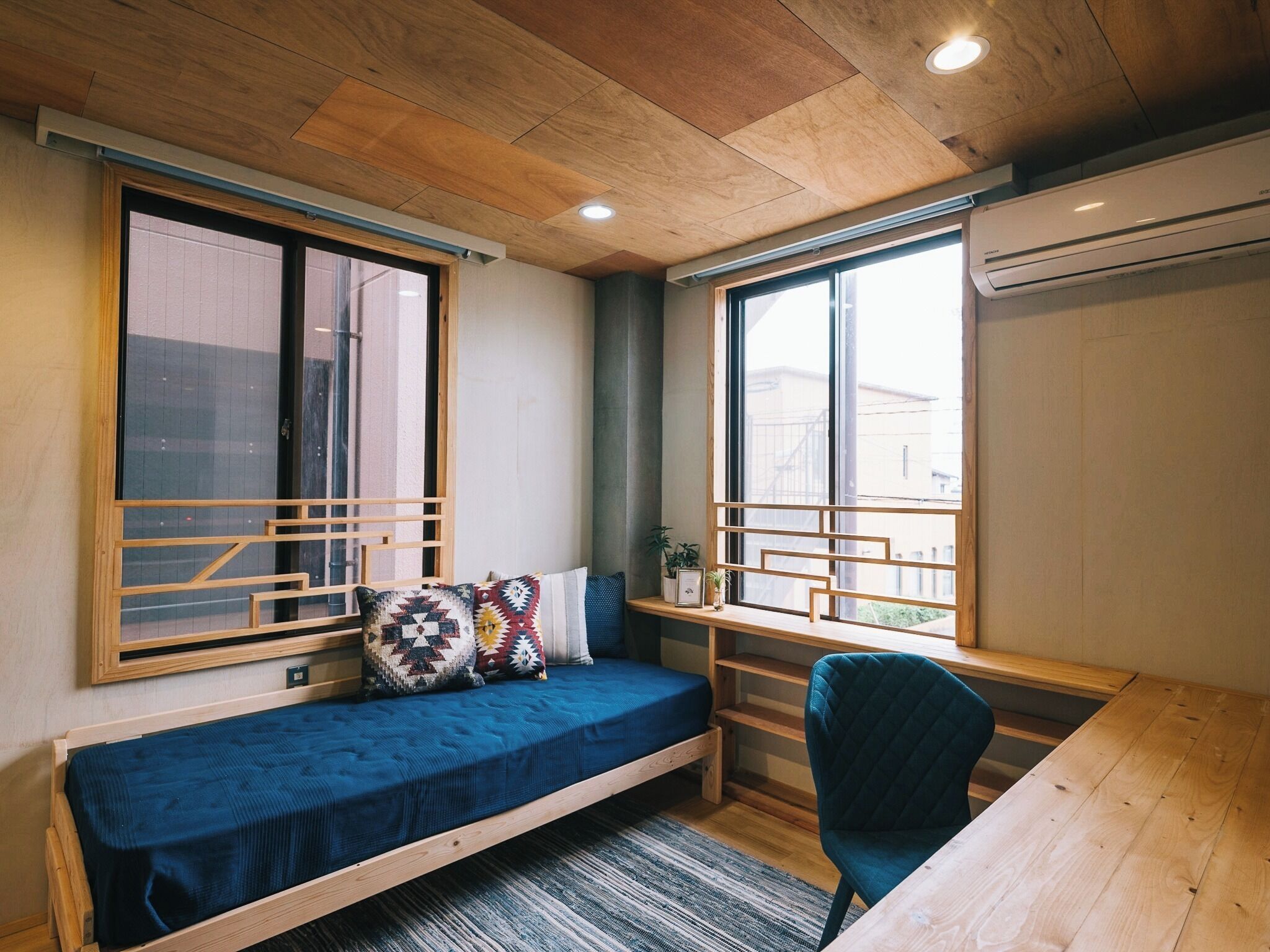 A compact room with a bed, a desk, and a chair.