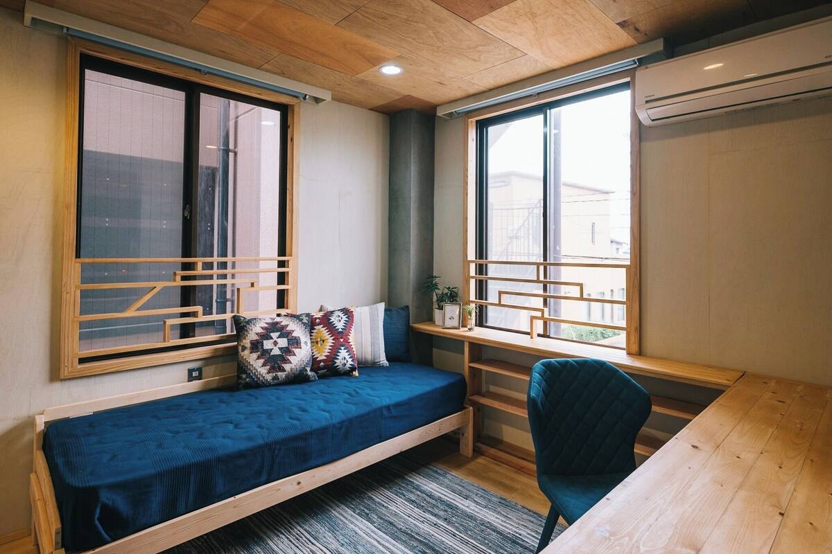 A compact room with a bed, a desk, and a chair.