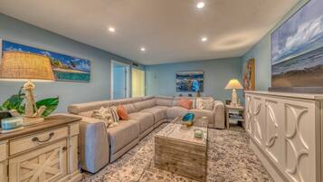 A living room with a sectional sofa, a coffee table, and a cabinet with decorative items.