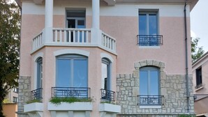 Un edificio a più piani con facciata in pietra, balconi e ampie finestre.