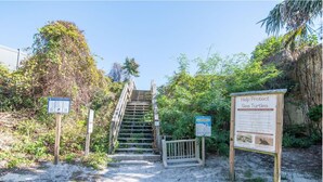Eine Treppe führt zu einem Strandabschnitt, wo Schilder über Meeresschildkröten Informationen geben.
