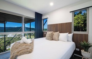 Une chambre moderne avec un grand lit, une vue sur un pont et un balcon.