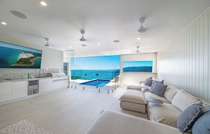 A modern living space with a kitchen, dining area, and a pool with a view.