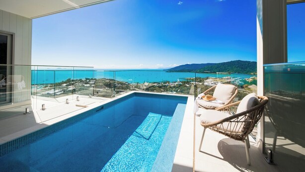 A pool with a clear view of the sea and a distant mountain range. - 180 Degree Ocean Views - 5 Bedroom - Heated Magnesium Swimming Pool (Airlie Beach)