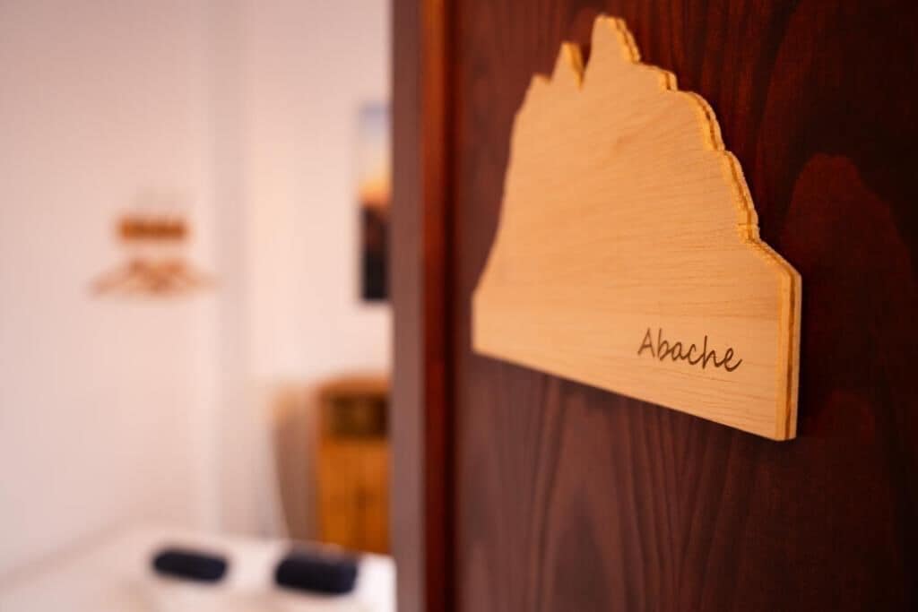 Un letrero de madera con la palabra 'Abache' en una puerta.