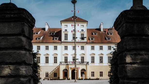 Ein großes, historisches Gebäude mit einer symmetrischen Fassade, zahlreichen Fenstern und einem zentralen Eingang.