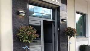 En hotellentrél med en skylt som visar texten ”Dream’s Hotel”, en dörr och två krukväxter.
