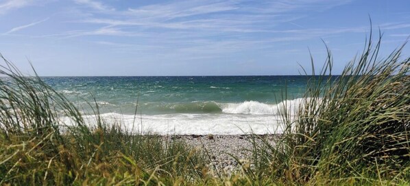 A beach with waves, grass, and a clear sky. - Historic house in Gammendorf on Fehmarn (Fehmarn)