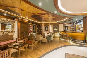 A bar area with wooden furniture, a bar counter, and a ceiling with a circular design. - Minia Cave Hotel Ortahisar (Ürgüp)