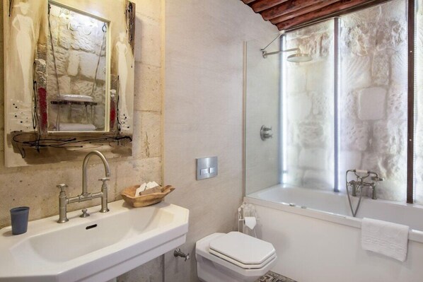 Ein Badezimmer mit Waschbecken, Spiegel, Toilette und Dusche.