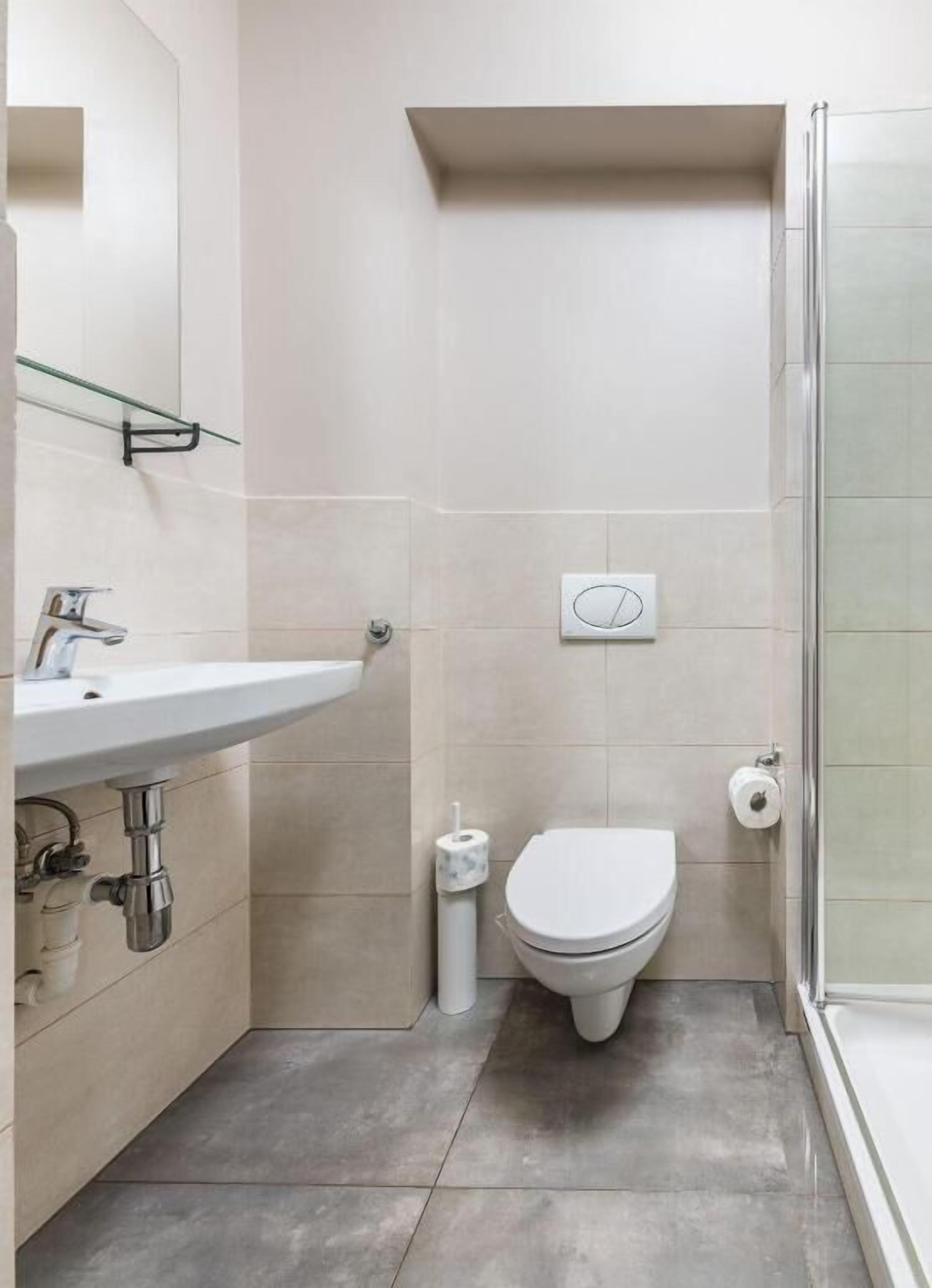 Un baño con inodoro, lavamanos y ducha.