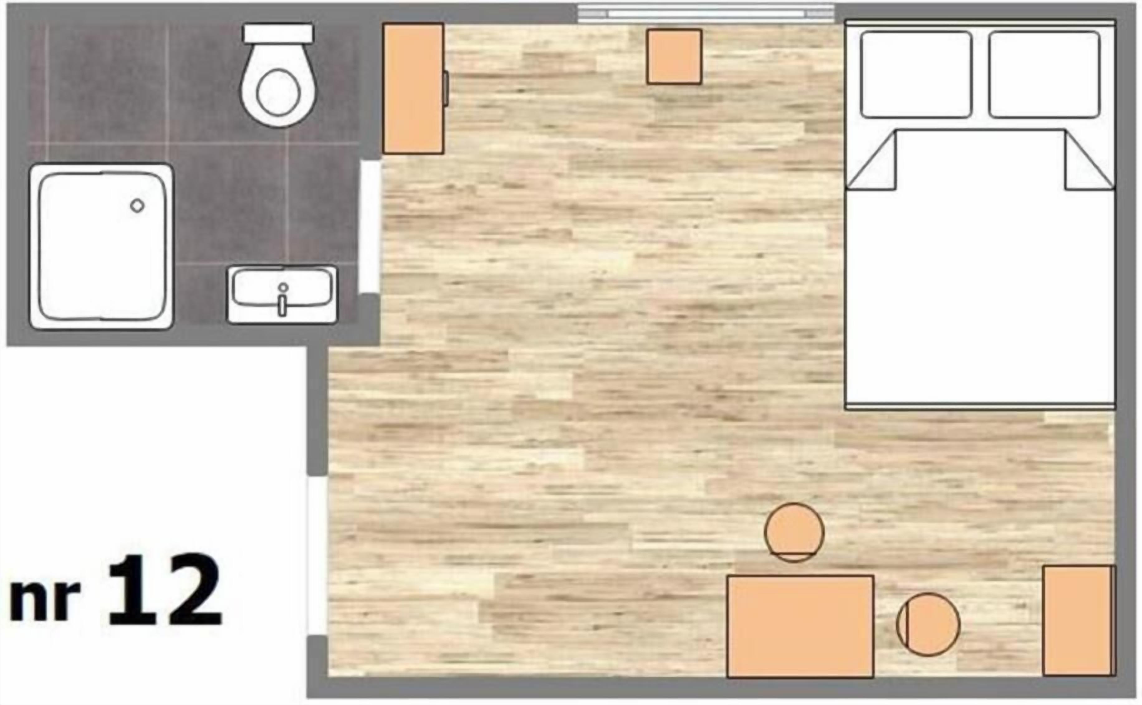 Distribución de una habitación de hotel que incluye un baño, una cama, un escritorio y una pequeña zona de estar.