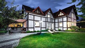 A traditional two-story house with a well-maintained lawn and a paved driveway.