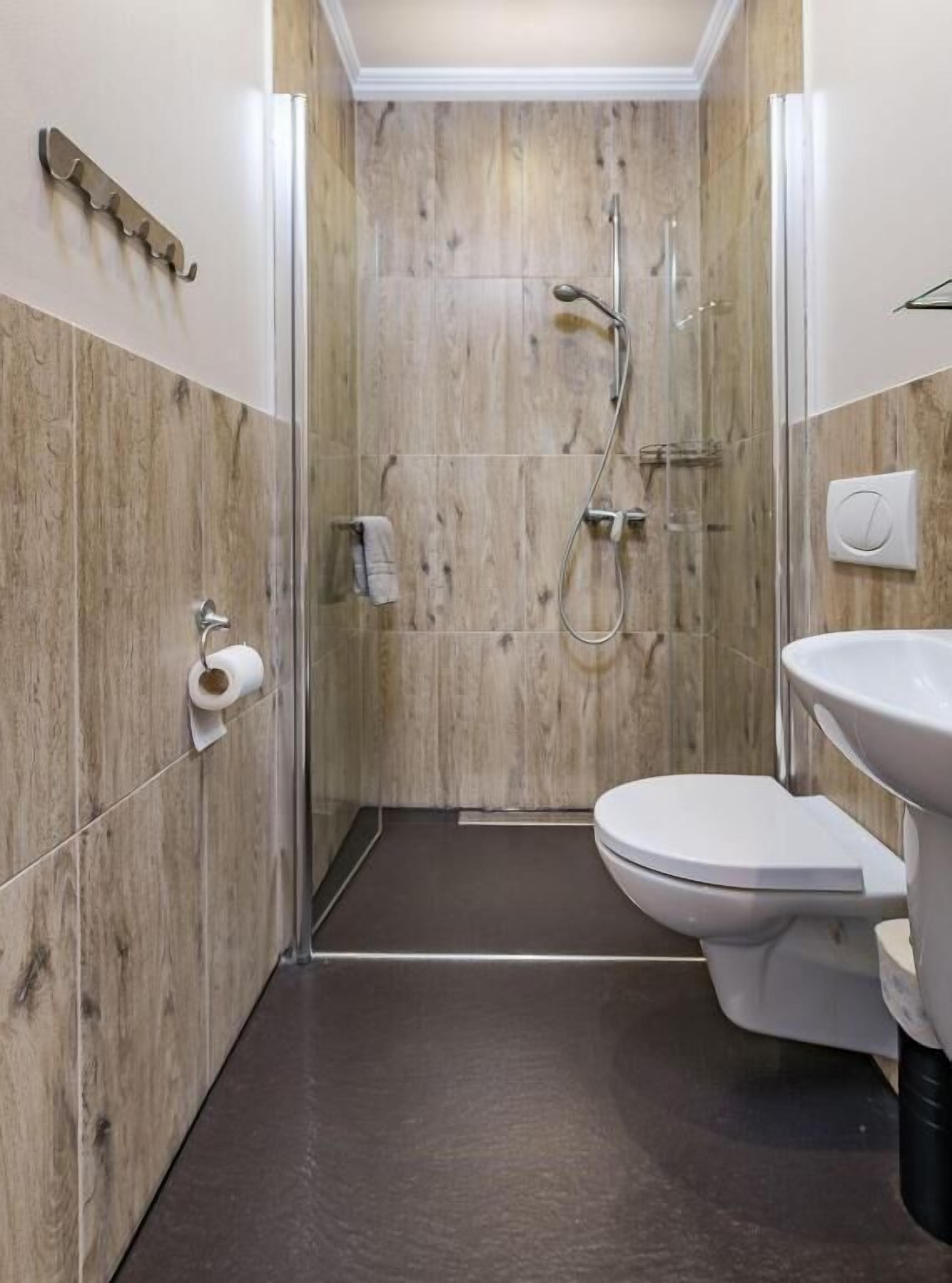 A bathroom with a shower, toilet, and sink.