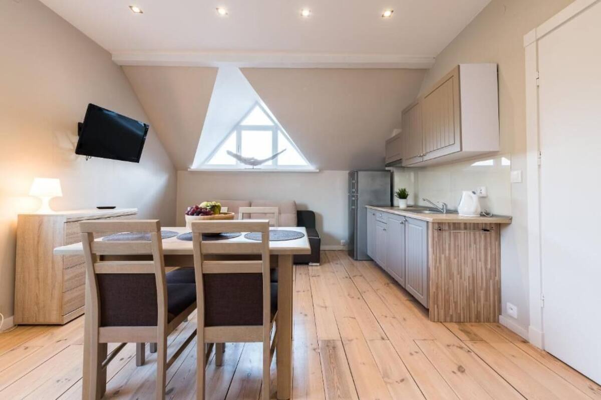 A modern kitchen with wooden cabinets, a built-in oven, and a window above the sink.