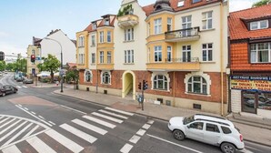 A multi-story building with a yellow facade, a visible entrance, and a small balcony. - Grand Belle Sopot - Near the beach (Sopot)